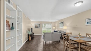 A spacious living area with a dining table and chairs, a sofa, and a bookshelf. - Spacious Comfort Haven (Montgomery)