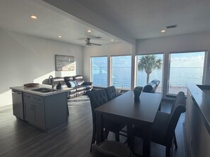 A modern kitchen with a dining area, large windows, and a view of the sea. - NEW Coastal property with AMAZING waterfront views!! (Bacliff)