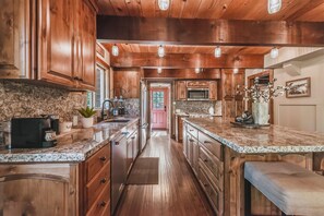 Your chef-worthy kitchen blends rustic charm with modern convenience, featuring warm wood cabinetry, gleaming granite countertops, and ample prep space for preparing memorable meals together. - Dog-Friendly Tahoe Family Home | Tahoma (Tahoma)