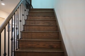 Un escalier en bois avec des balustres noires et une main courante.