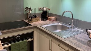 Una cocina moderna con una campana de acero inoxidable, un lavamanos doble y un horno empotrado.