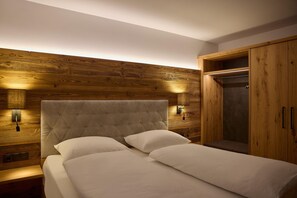 Ein Schlafzimmer mit einem großen Bett, einem Holzkopfstück, zwei Nachttischlampen und einem Kleiderschrank.