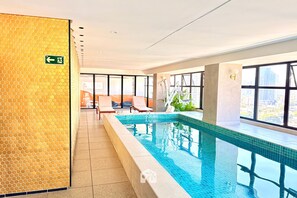 A hotel room with a large window, a pool, and a view of the city. - FR Bueno de Alto Padrão Lazer Premium (Goiânia)