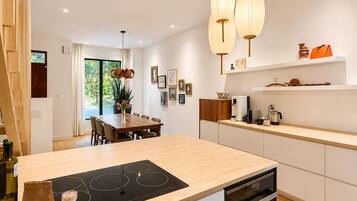 A modern kitchen with a central island, built-in appliances, and pendant lighting.