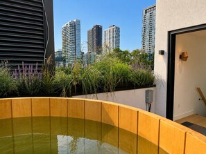 Ein Dachgarten mit Wasserspiel, umgeben von hohen Gebäuden.