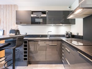 A modern kitchen with a built-in oven, a sink, and a coffee machine. - Functional studio, mountain view - 4 guests (La Toussuire)