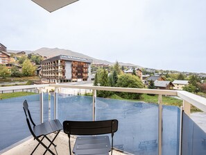 A balcony with a view of a hotel building named 'Les Soldanelles' and surrounding residential buildings. - Renovated studio, mountain view - 4 guests (La Toussuire)
