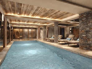 A modern indoor pool area with lounge chairs and a stone wall. - Luxury apartment, mountain view - 8 guests (Méribel)