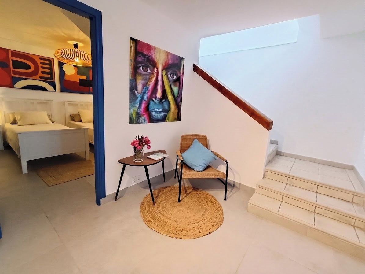 A modern living room with a sofa, a chair, a small table, and a painting on the wall.