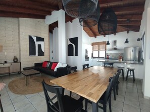 A modern kitchen with a wooden dining table, black chairs, and a built-in oven.