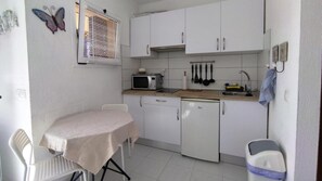 A compact kitchenette with a microwave, sink, and cabinets. - Casa Dan "Pool Views & Excellent Private Garden Terrace" (Corralejo)