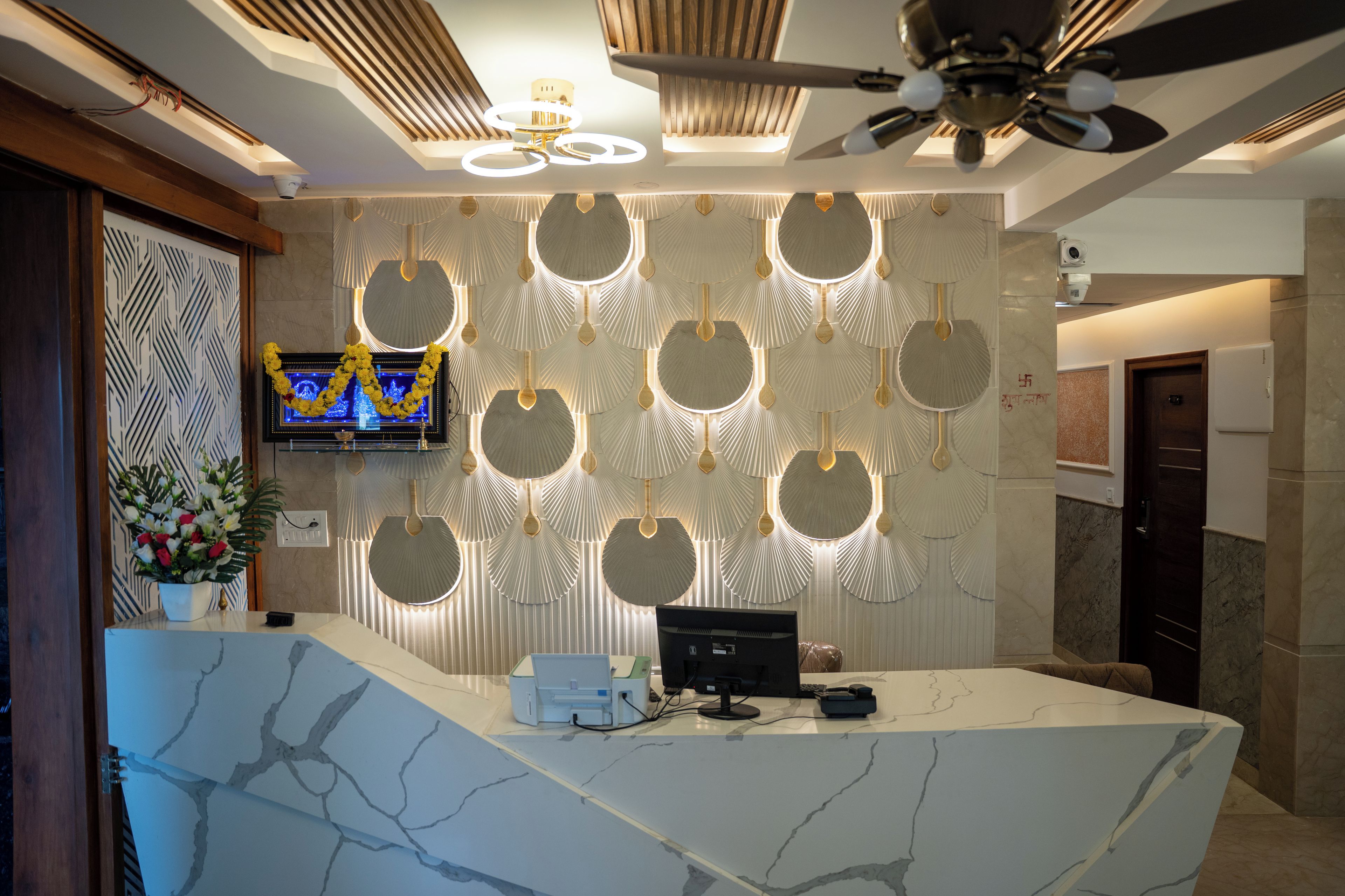 Una recepción con diseño moderno, un ventilador de techo y un televisor de pantalla plana montado en la pared.