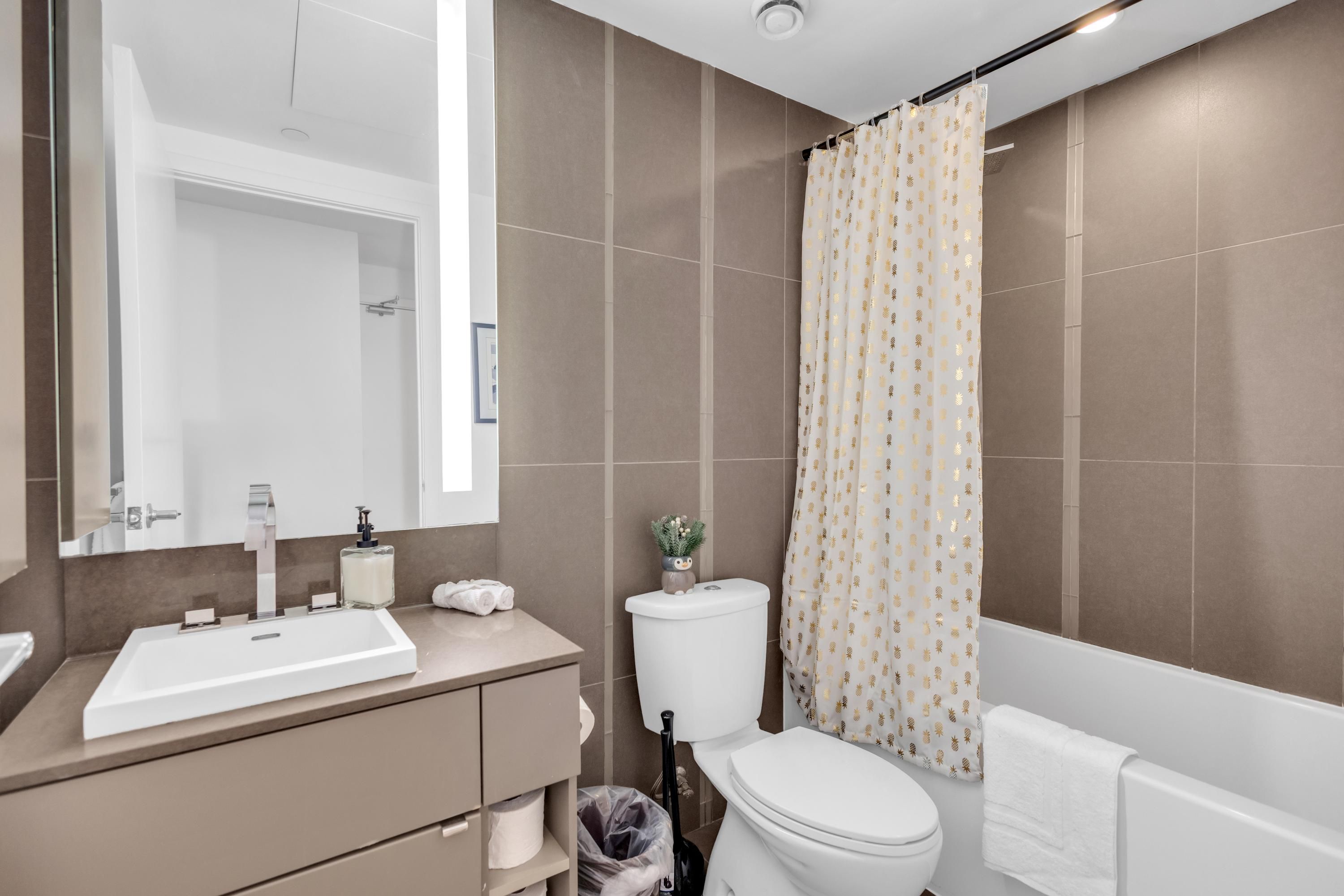A bathroom with a sink, toilet, and shower curtain.