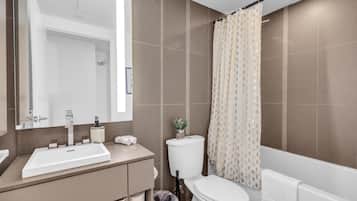 A bathroom with a sink, toilet, and shower curtain.