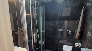A modern bathroom with a glass shower enclosure, a toilet, and a sink. - Charming Countryside Apartment Near Koping - Pet Friendly! (Köping)
