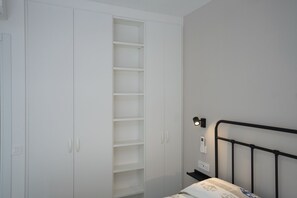 Ein Schlafzimmer mit Bett, Kleiderschrank und Nachttisch.