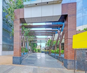 A covered walkway with a modern architectural design, leading to a building entrance. - Classic King Room Palette Gangakash (Nagpur)