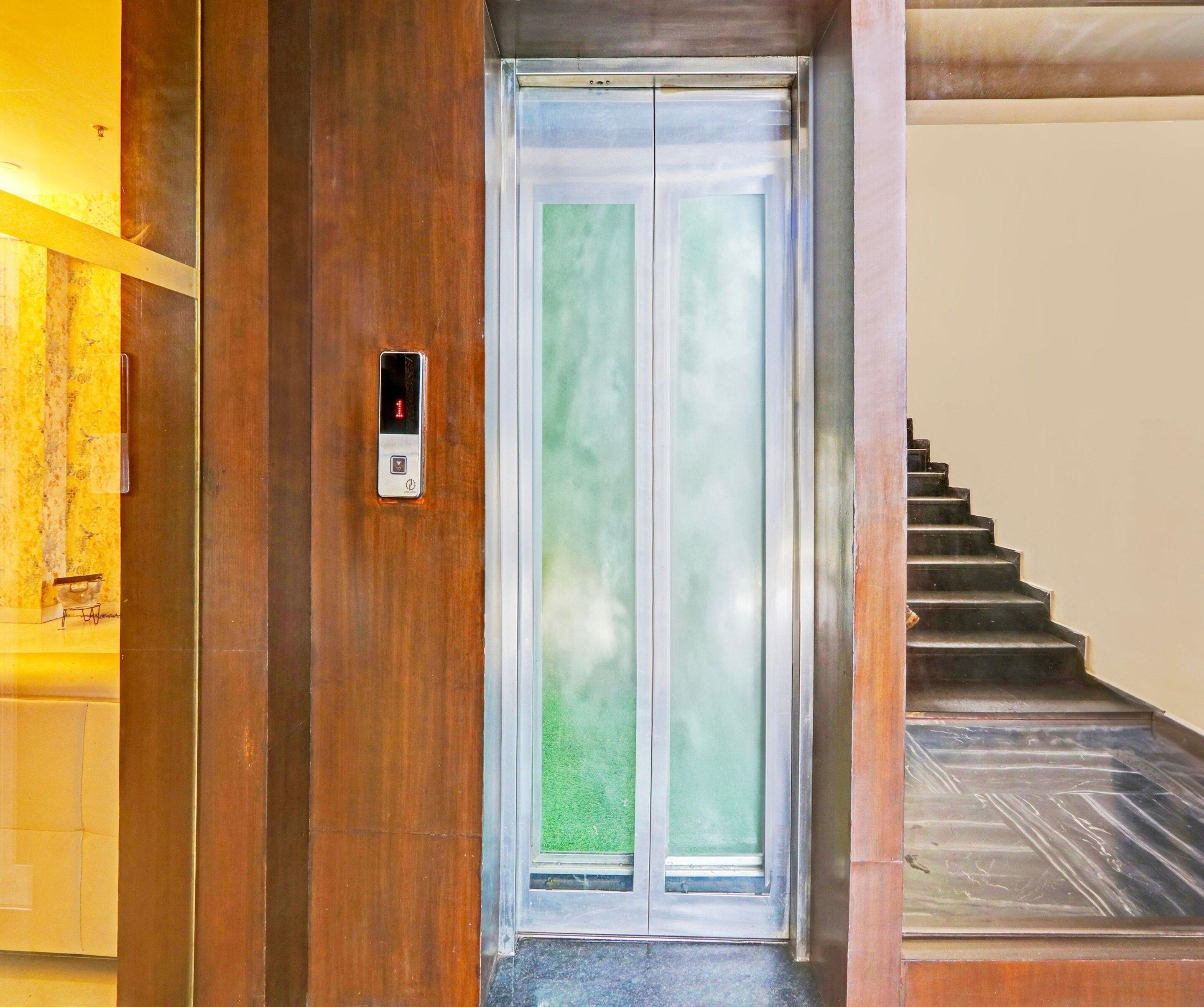 A wooden door with a glass panel and a digital elevator control panel.