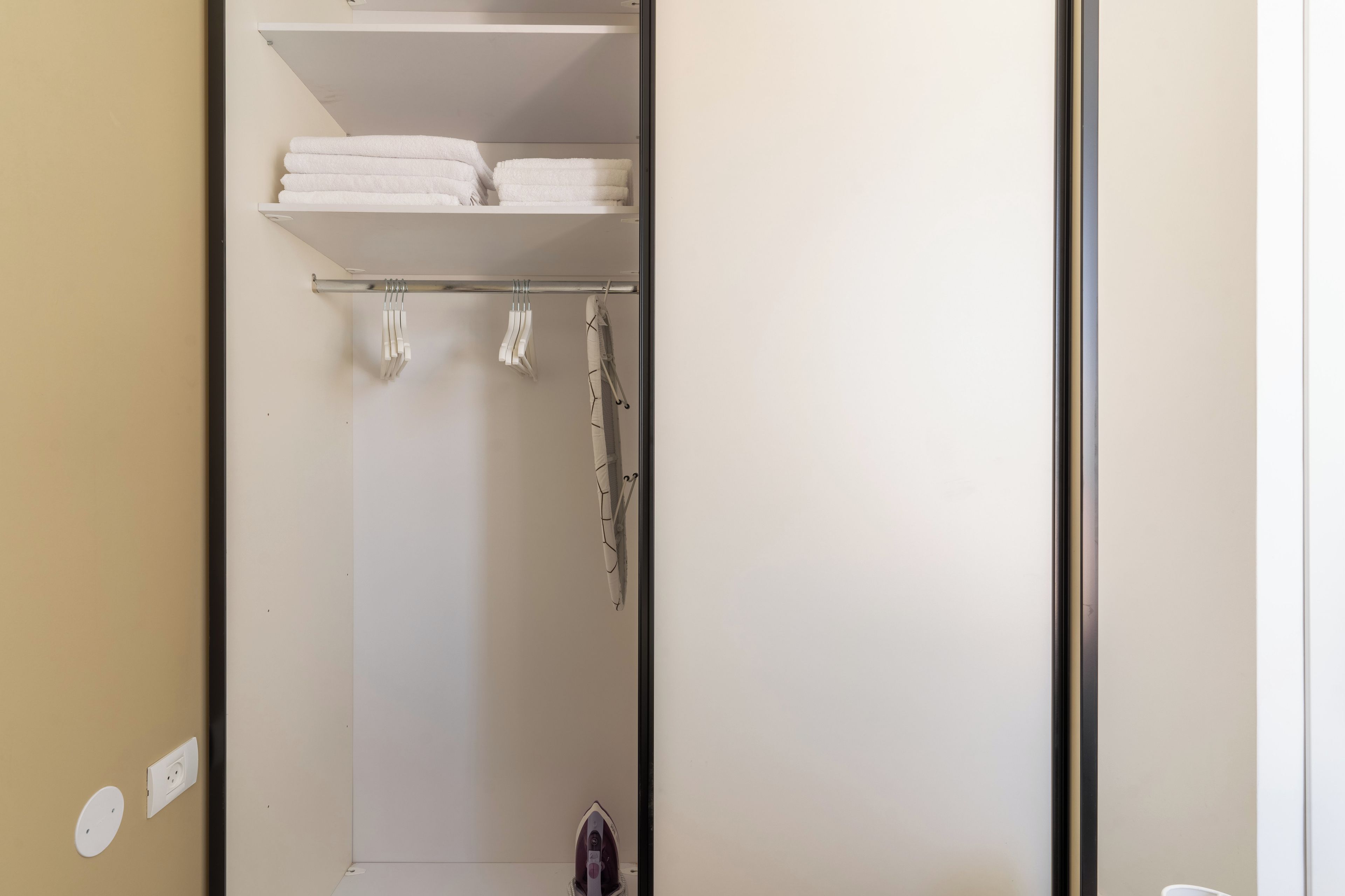 Un baño con toallero, una toalla colgada y zona de ducha.