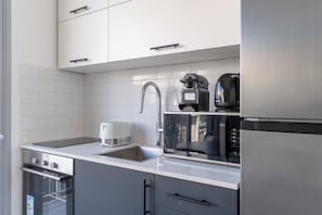 A modern kitchen with stainless steel appliances, a built-in oven, and a dishwasher.