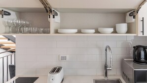 Eine Küche mit Toaster, Spüle und Wasserkocher auf der Arbeitsplatte.