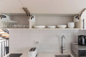 A kitchen with a toaster, a sink, and a kettle on the counter. - Blueground Florentine Bright Apartments (Tel Aviv-Yafo)