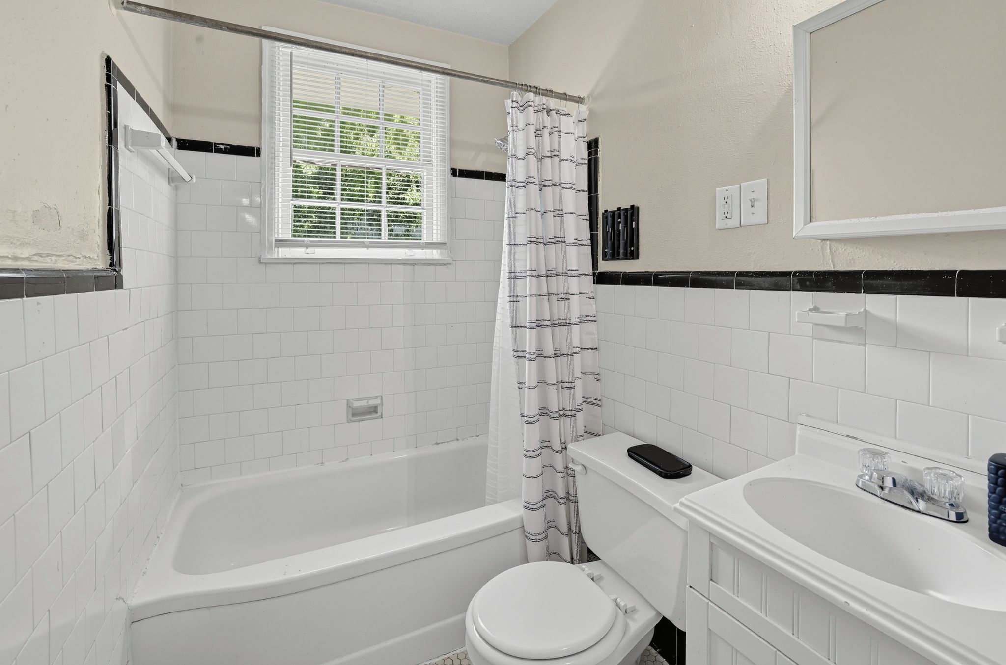 A bathroom with a bathtub, toilet, and sink.