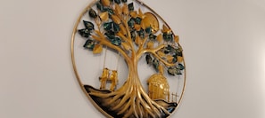 Eine Wanddekoration mit Baum, Vögeln und Haus.