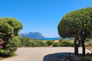 Ein Parkplatz mit Blick auf ein Gebirge und das Meer.