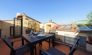 An outdoor patio with a table set for dining, surrounded by chairs. - BEAUTIFUL FLORENCE APARTMENT WITH PRIVATE TERRACE NEAR THE DUOMO (Firenze)