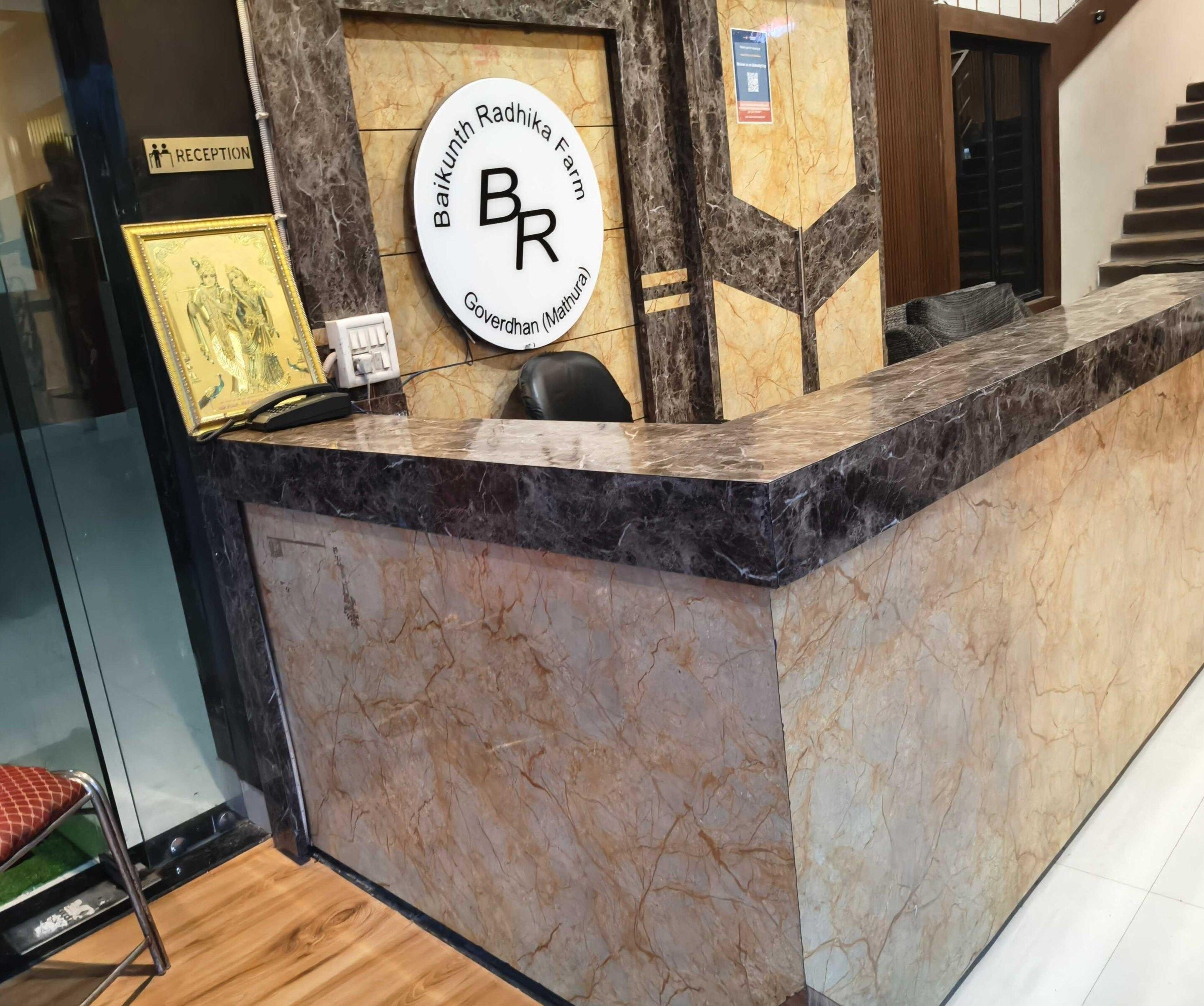 A reception desk with a marble top, a framed sign above it, and a chair to the left.