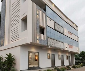 A modern two-story building with a flat roof, large windows, and a symmetrical facade.