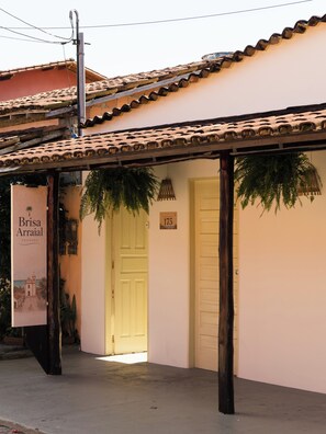 Un edificio con techo de tejas, una puerta con la leyenda 'Brisa Arraial' y un cartel con el número '175'.