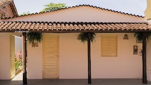Um edifício com telhado em cerâmica, duas portas e um alpendre coberto.