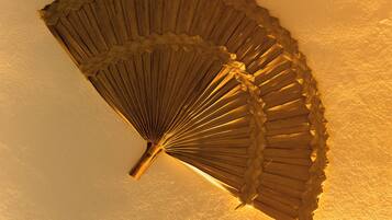 Ventilador de teto com design em madeira diante de uma parede lisa.