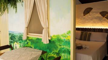A room with a bed, a table, and a window with curtains.