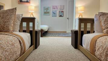 A bedroom with two beds, a door, and a wall with motivational posters.