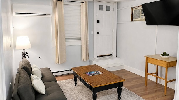 Ein Wohnzimmer mit Sofa, Couchtisch und Fernseher auf einem Schrank.
