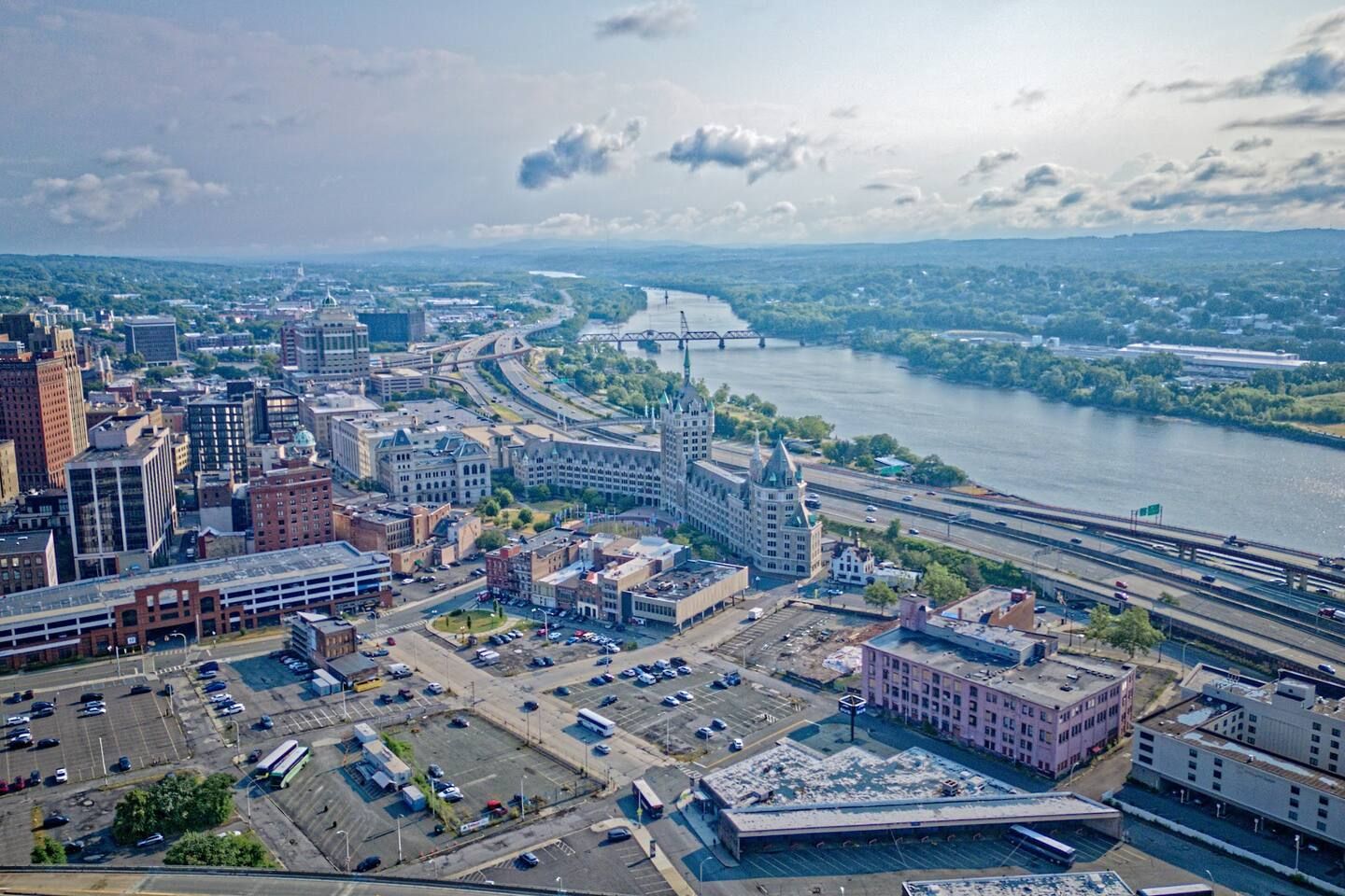 A cityscape with a river, bridges, and a mix of modern and historic buildings.