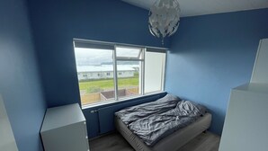 Ein Schlafzimmer mit einem Bett, einem Fenster und einer Heizung.