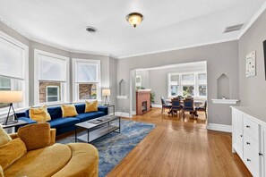 A spacious living room with a blue sofa, a coffee table, and a fireplace.