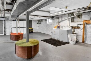 Ein geräumiger Raum mit hoher Decke, freiliegenden Lüftungsrohren und einer zentralen Säule.