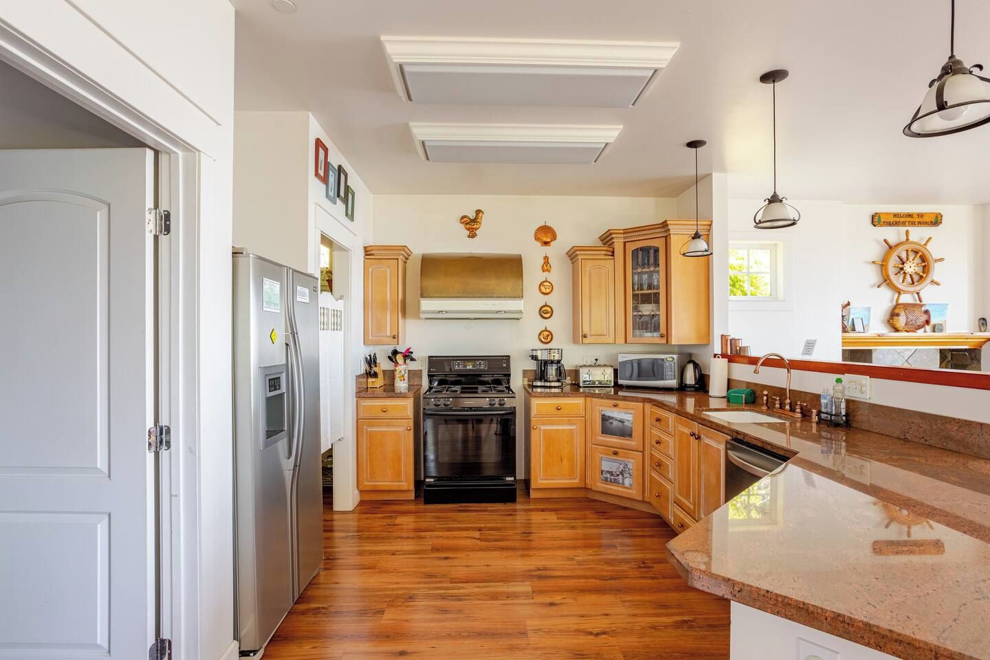 A kitchen with wooden cabinets, a stainless steel refrigerator, a stove, and a microwave.