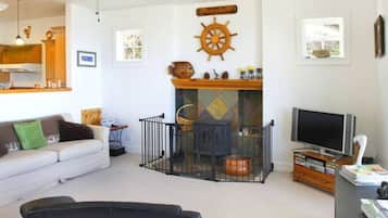A living room with a fireplace, a television, and a sofa.
