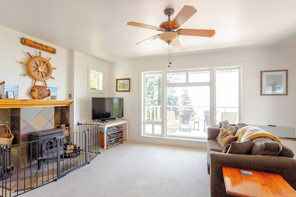 A living room with a fireplace, television, and a large window.