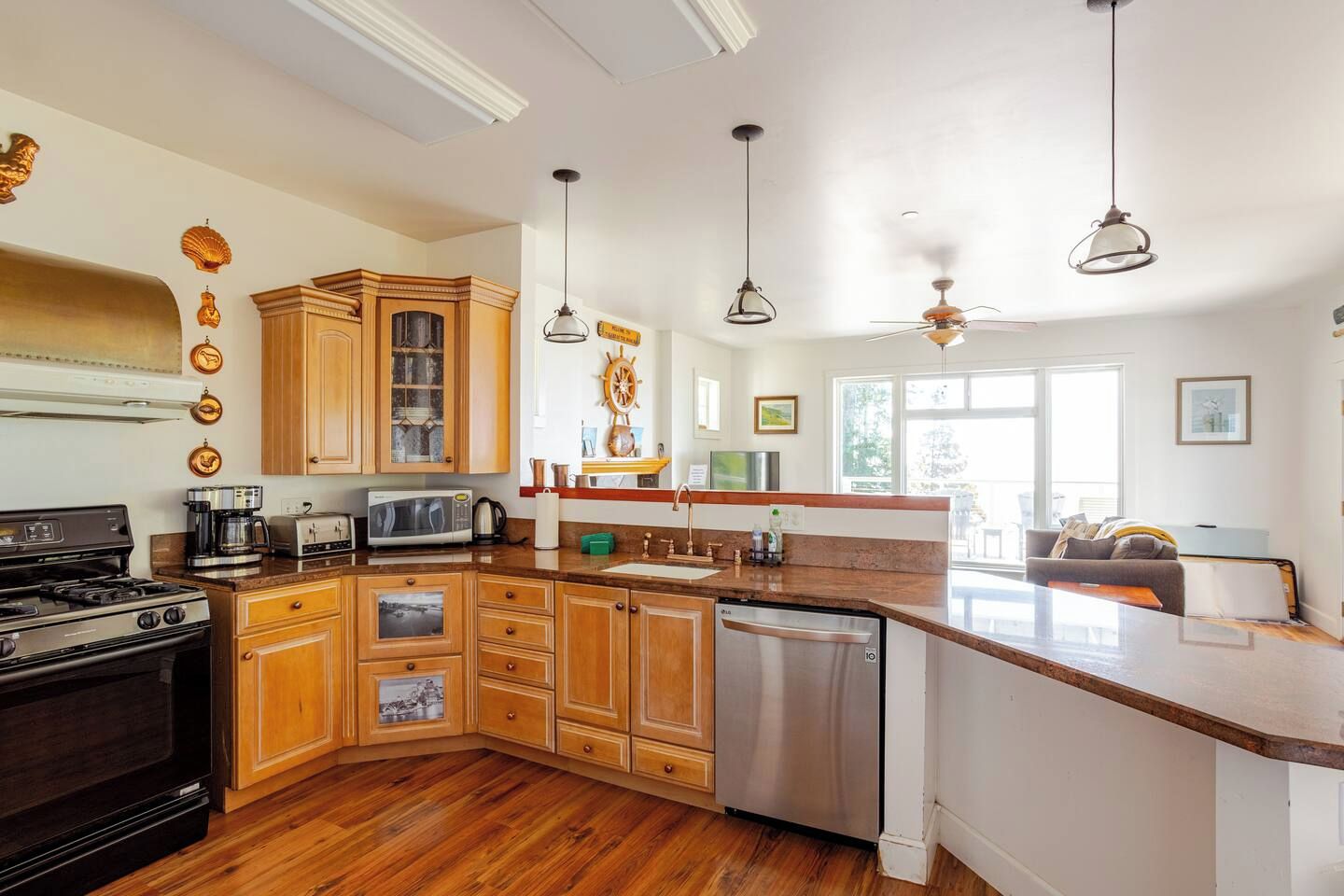 A modern kitchen with wooden cabinets, a built-in oven, a dishwasher, and a large island with a sink.
