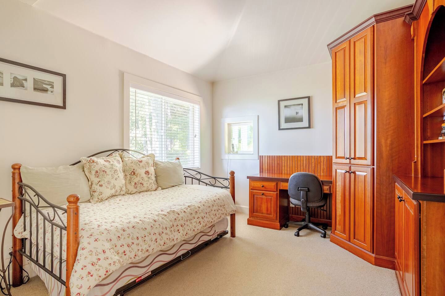 Ein Schlafzimmer mit Bett, Schreibtisch und Kleiderschrank.