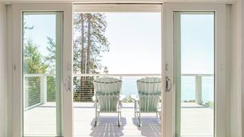 A deck with two chairs and a view of the ocean.