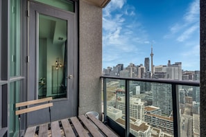 Un balcón con vistas a la silueta urbana, incluyendo una torre destacada.