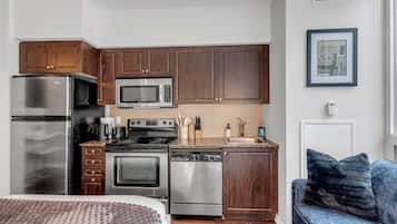 Una cocina moderna con electrodomésticos de acero inoxidable, armarios de madera y un horno empotrado.